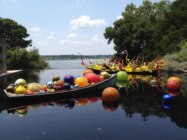 Chihuly glass exhibit of colorful balls in water. 