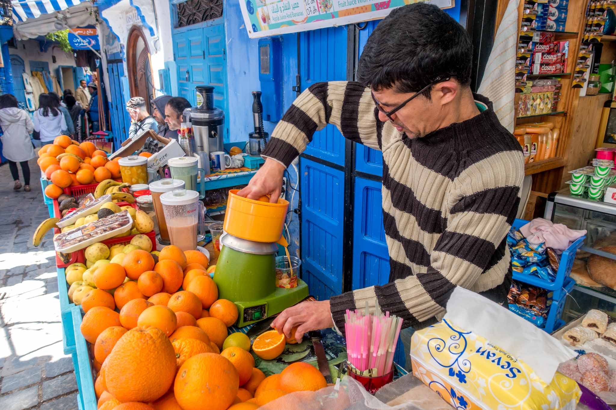 Man making fresh orange juice at a juice stand