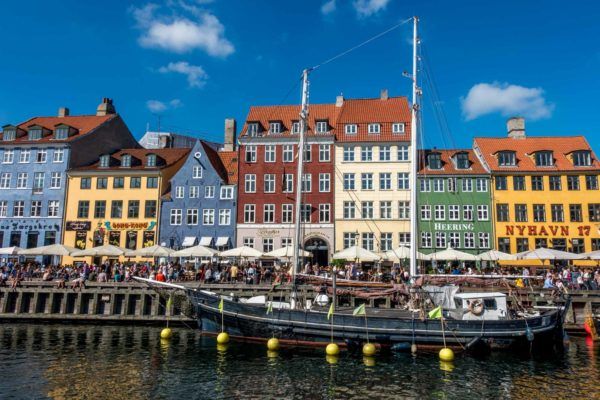 Brightly colored buildings and a boat in a Copenhagen harbor