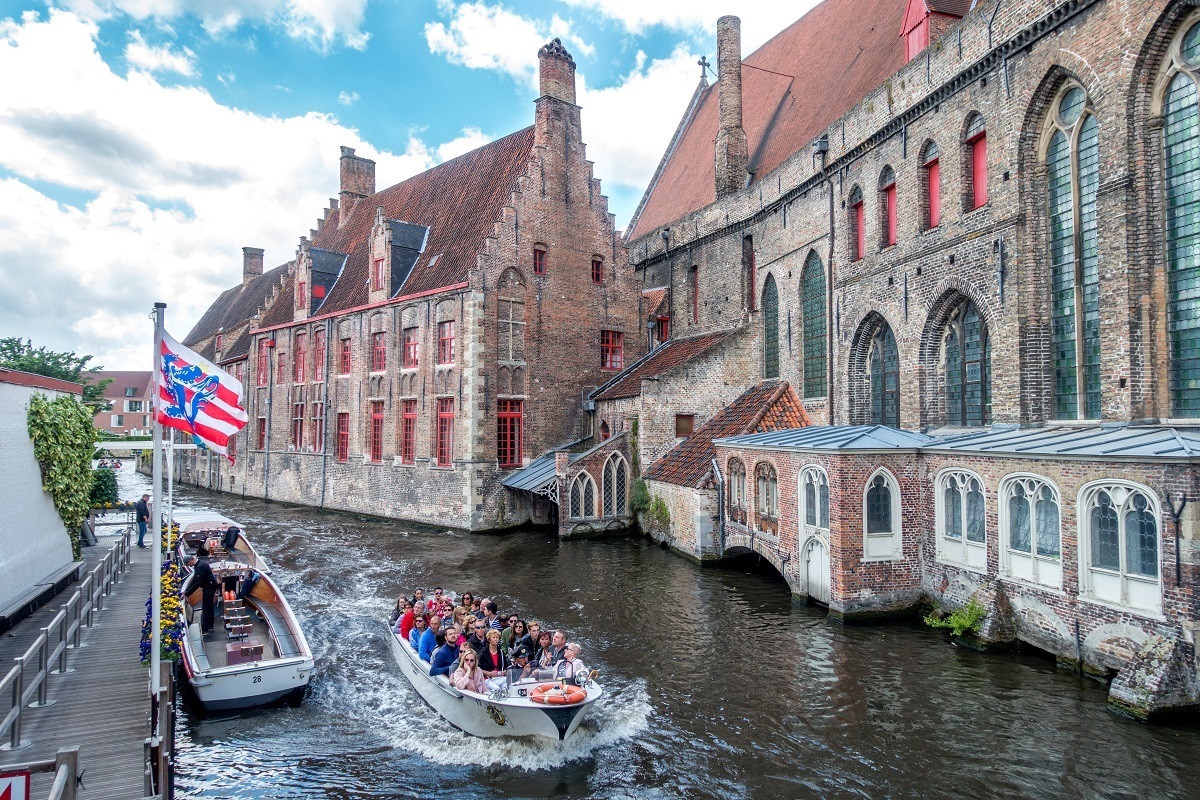 Boat in canal in Bruges, Belgium. Which is better—Ghent or Bruges?
