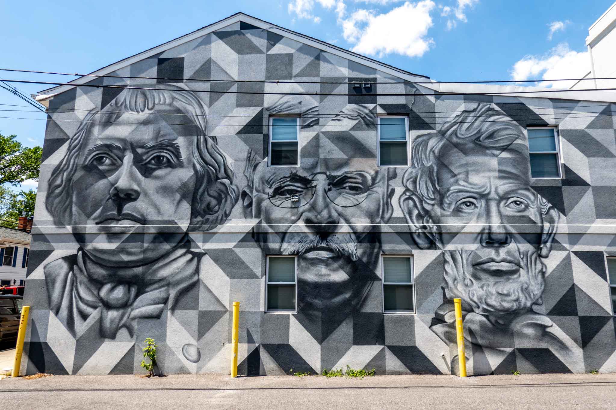Black, white, and gray street art mural featuring the faces of three men--Abraham Lincoln, Teddy Roosevelt, and James Madison