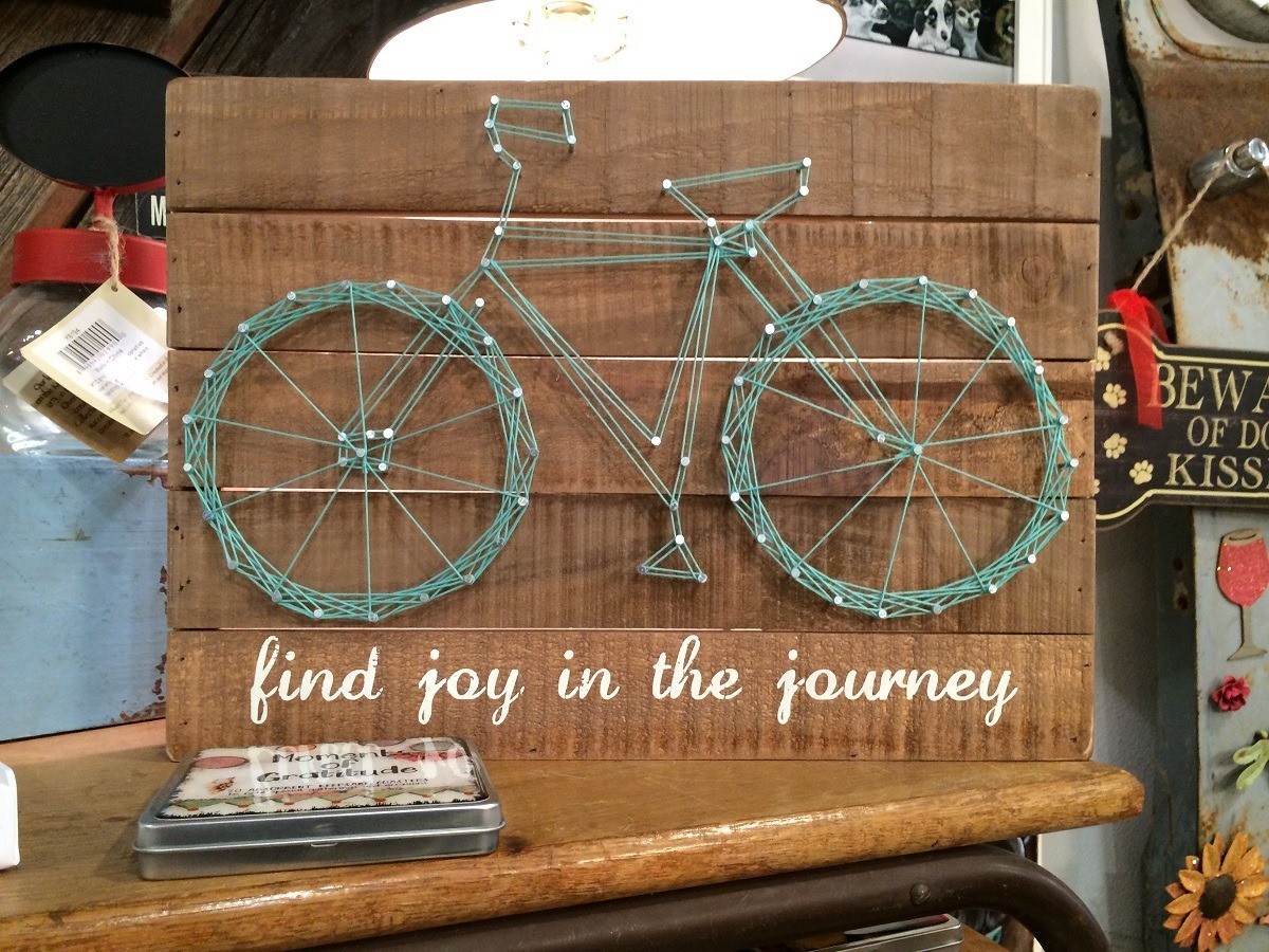 Decoration featuring bicycle and labeled "find the joy in the journey." 
