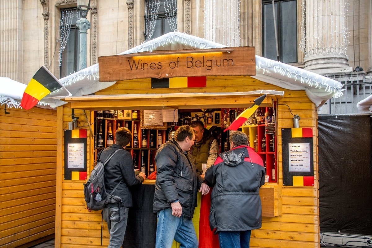 People at market stall selling wines of Belgium