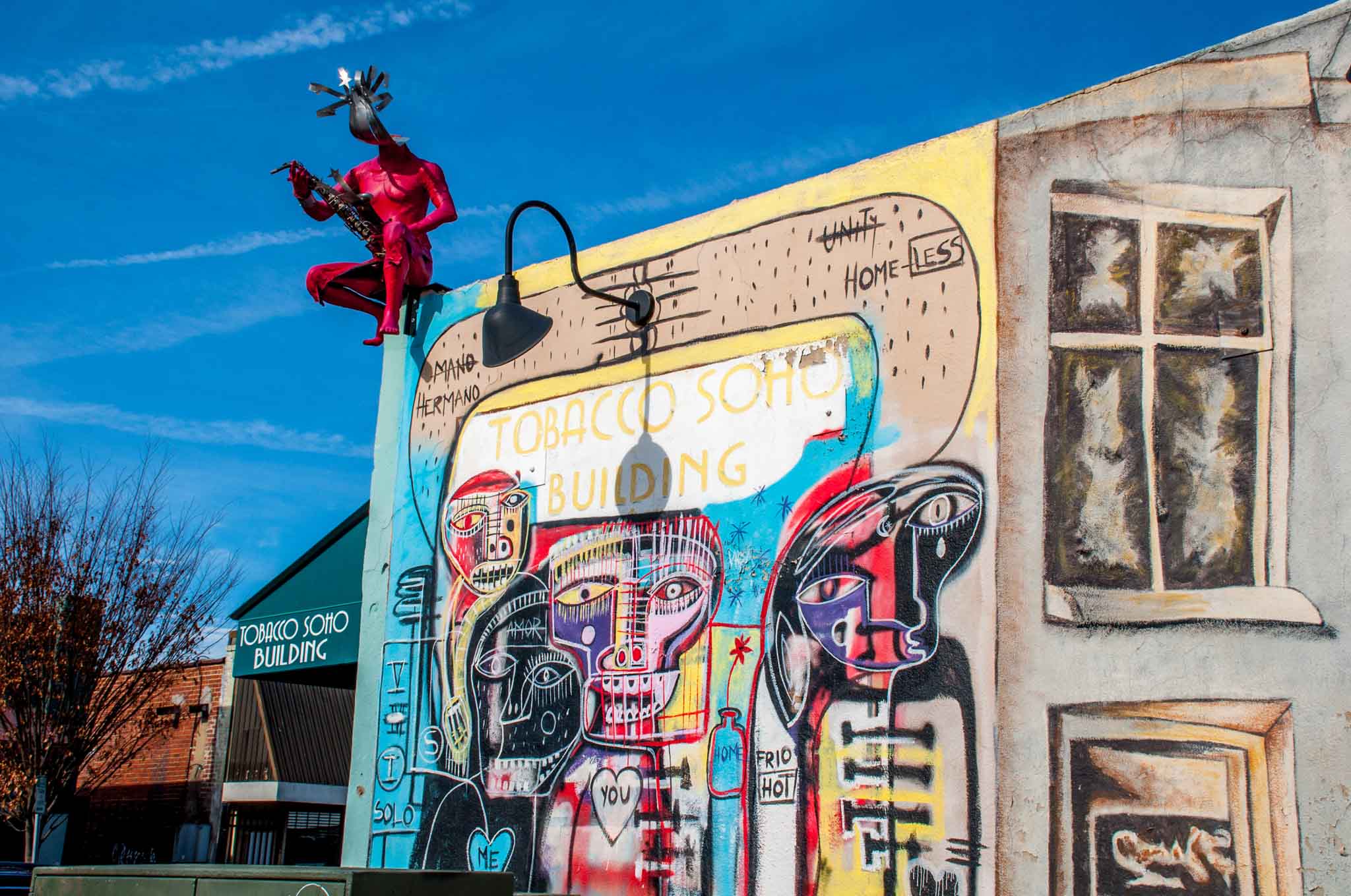 Street art mural showing colorful figures on the Tobacco Soho Building in Winston Salem NC