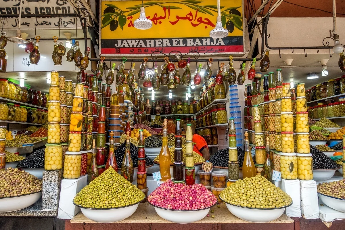 Piles and jars of olives for sale
