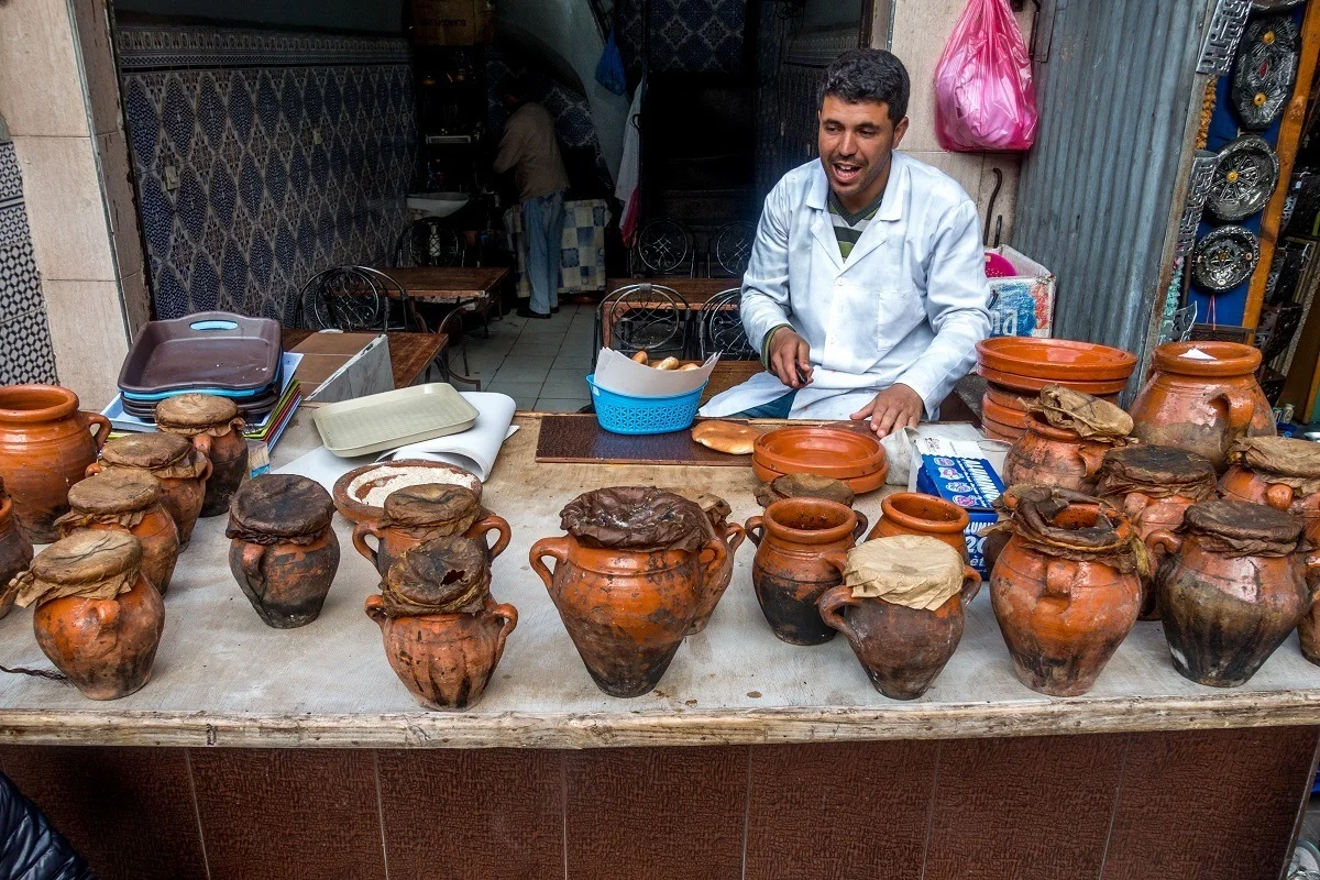 Man with clay pots on table at a restaurant